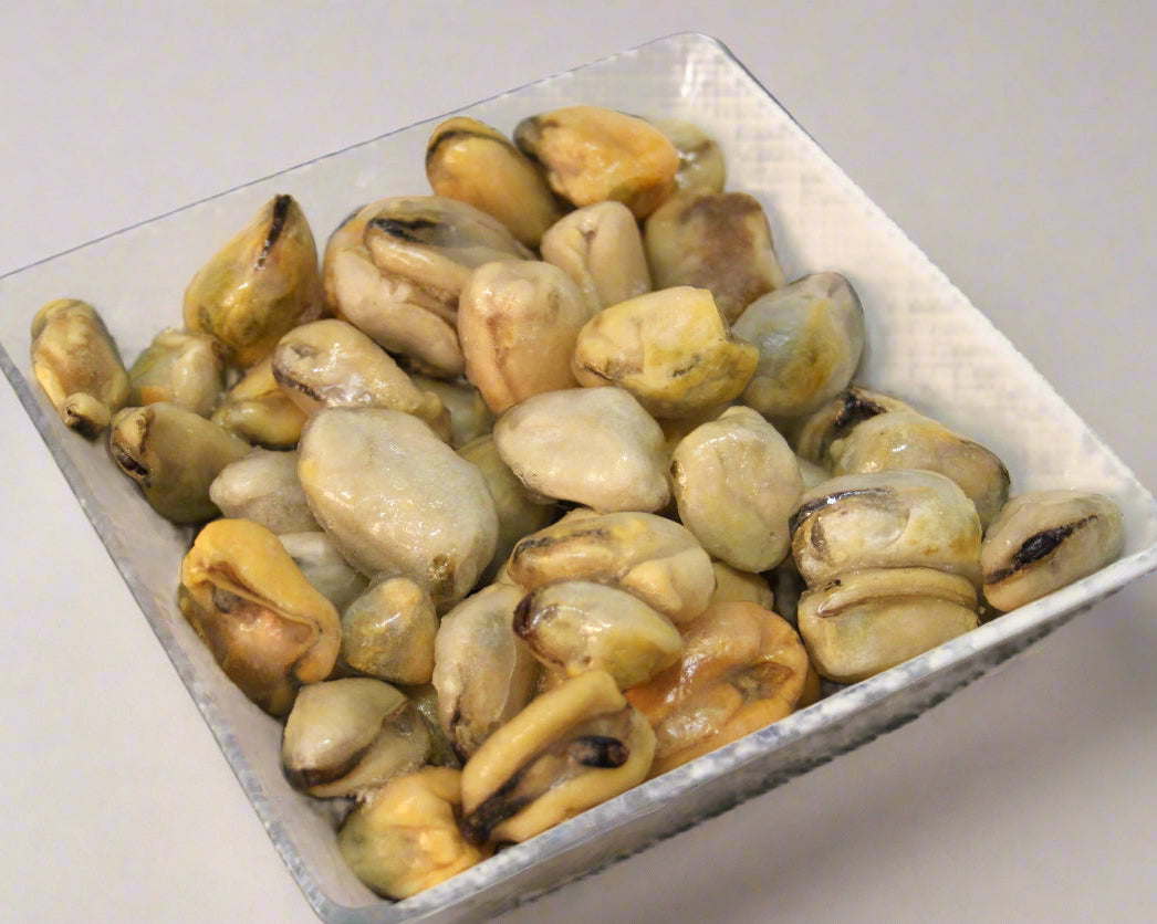 White bowl filled with mussel meat on a black background